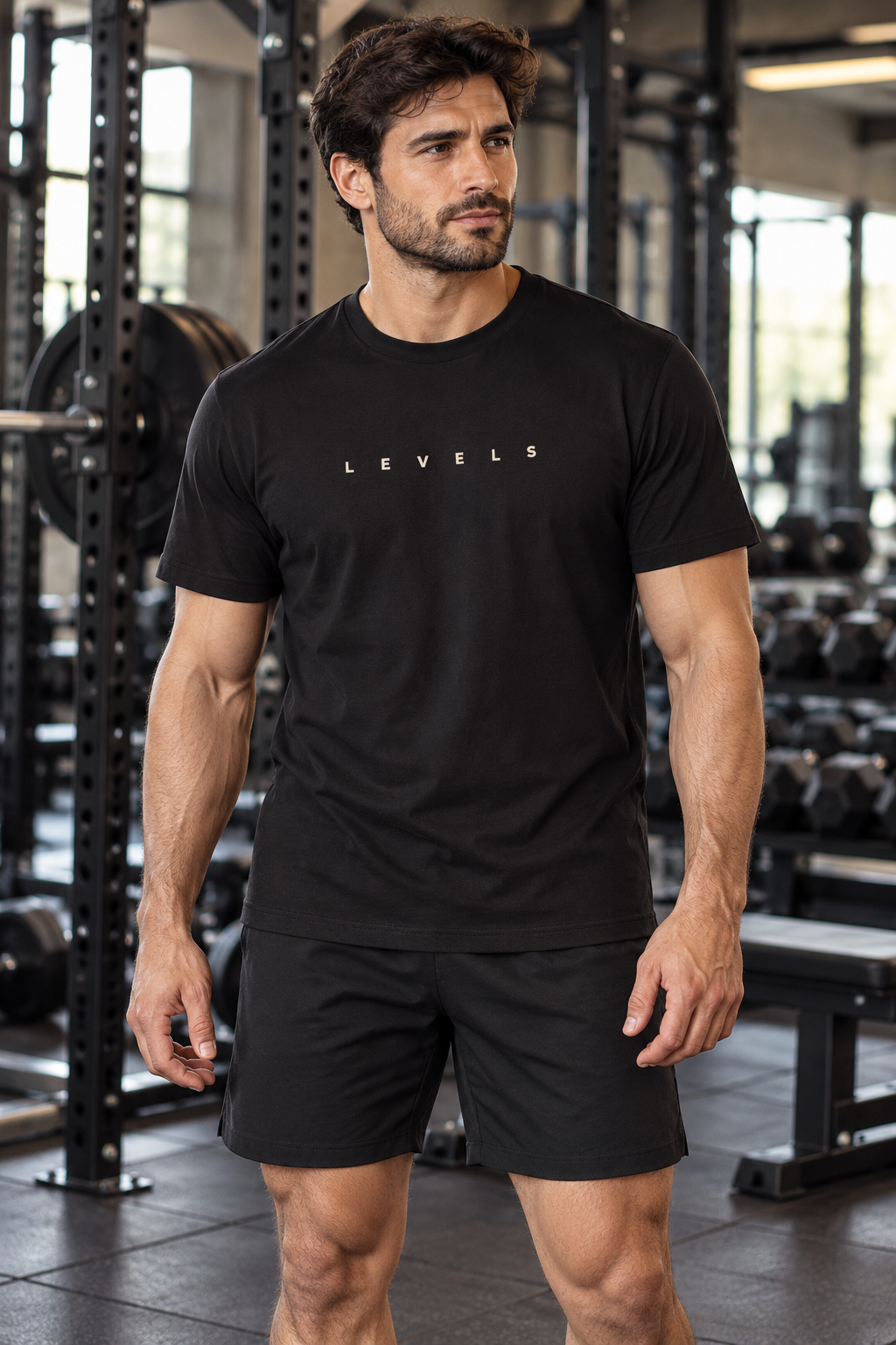 Exemplo de modelo masculino adulto com roupa fitness preta, de frente em academia.